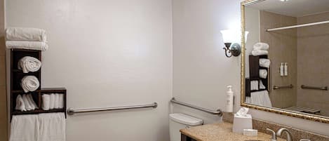 A bathroom with a sink, toilet, and a towel rack with towels.