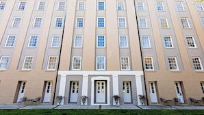A multi-story hotel with a symmetrical facade, large windows, and a central entrance with a door. - Hampton Inn Charleston-Historic District (Charleston)