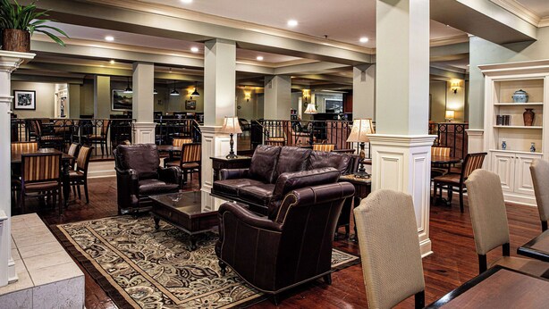 A spacious lobby with leather sofas, wooden tables, and a patterned rug. - Hampton Inn Charleston-Historic District (Charleston)