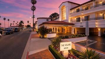 A hotel with a sign reading 'The Volare Enter' and a parking lot.