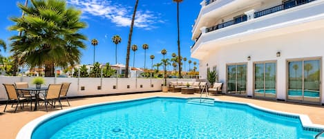 Una piscina al aire libre, sillones reclinables de piscina