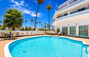 Una piscina al aire libre, sillones reclinables de piscina