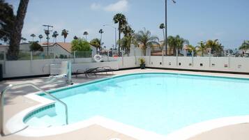 Een buitenzwembad en ligstoelen