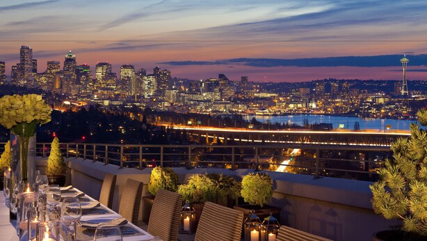 A rooftop dining area with a city skyline view, including a prominent tower, and a table set for dining. - Graduate by Hilton Seattle (Seattle)