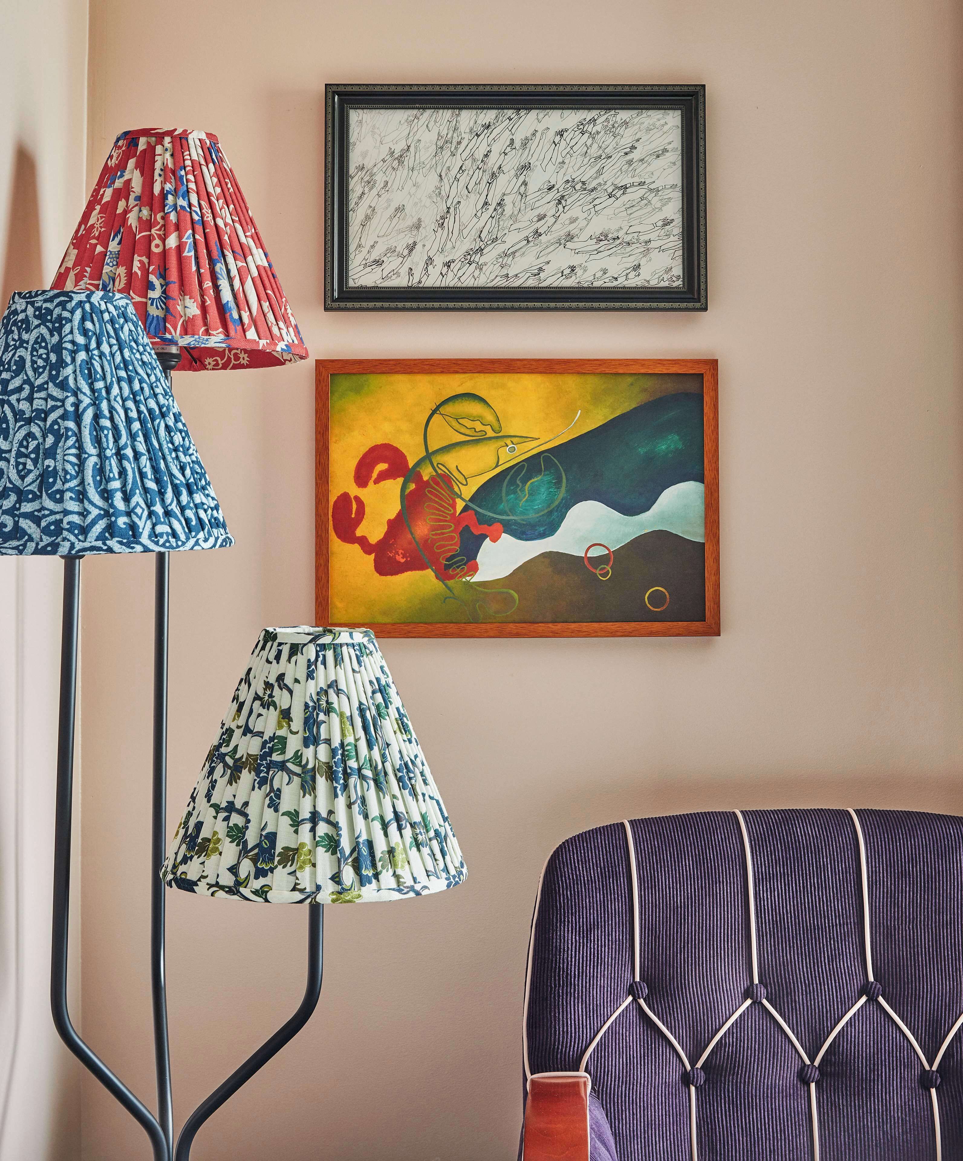 A room with a floor lamp, a framed abstract painting, and a patterned chair.