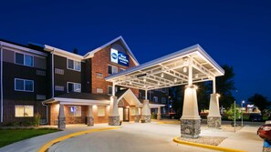 A hotel with a covered entrance, multiple windows, and a clear sign for Best Western Inn & Suites. - Best Western Harvest Inn & Suites (Grand Forks)