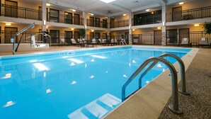 A hotel pool area with multiple levels, a lifeguard stand, and lounge chairs.