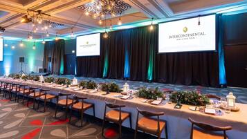A conference room with a long table set for a meeting, featuring a logo for Intercontinental Wellington.