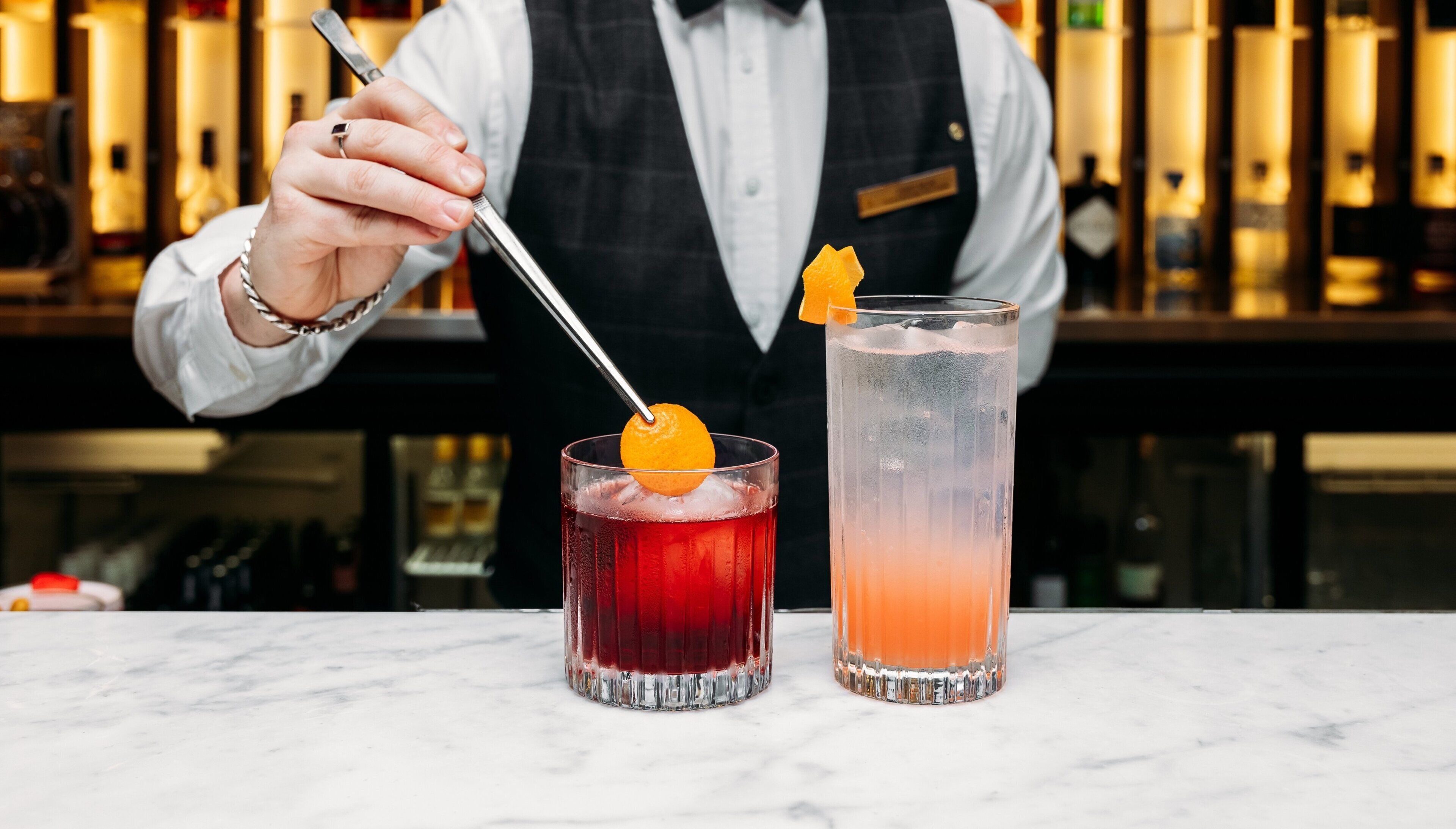 A bartender preparing drinks at a bar.
