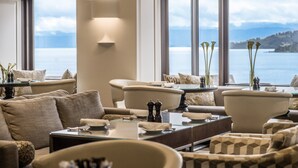 A modern living room with a view of the sea, featuring a sofa set, a coffee table, and a side table with decorative items. - InterContinental Wellington by IHG (Wellington)