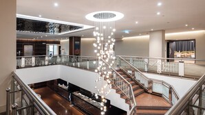 A spacious lobby with a central staircase, a reception desk, and a modern chandelier. - InterContinental Wellington by IHG (Wellington)