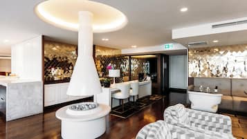 A modern hotel lobby with a central white column, seating area, and a reception desk.