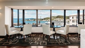 A room with a large bay window, a dining table with four chairs, and a patterned rug. - InterContinental Wellington by IHG (Wellington)
