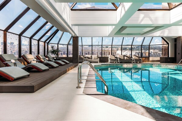 Una piscina techada, sillones reclinables de piscina