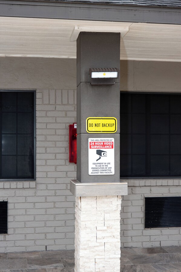 A security sign with a do not backup warning and a 24-hour video surveillance notice.