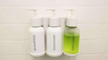 Três frascos de artigos de higiene: shampoo, condicionador e gel de banho.