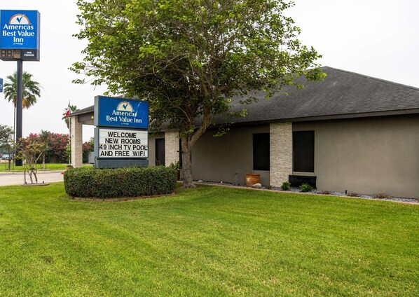 A building with a sign advertising new rooms with a 49-inch TV pool and free WiFi. - Americas Best Value Inn Harlingen (Harlingen)