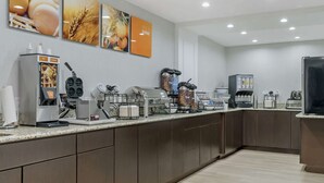 Cocina moderna con estación de café, que incluye una cafetera, molinillo y diferentes cápsulas de café.