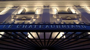 De ingang van Le Chateaubriand, met klassieke architectuur en een bord boven de deur.