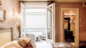 Een hotelkamer met een bed, een tafeltje en uitzicht op het balkon.
