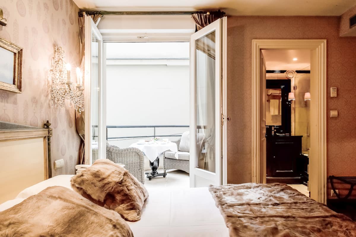 Une chambre d’hôtel avec un lit, une petite table et une vue sur le balcon.