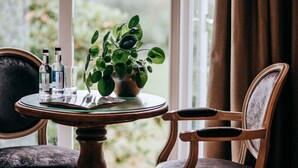 Een tafel met een potplant, twee flessen en een glas.