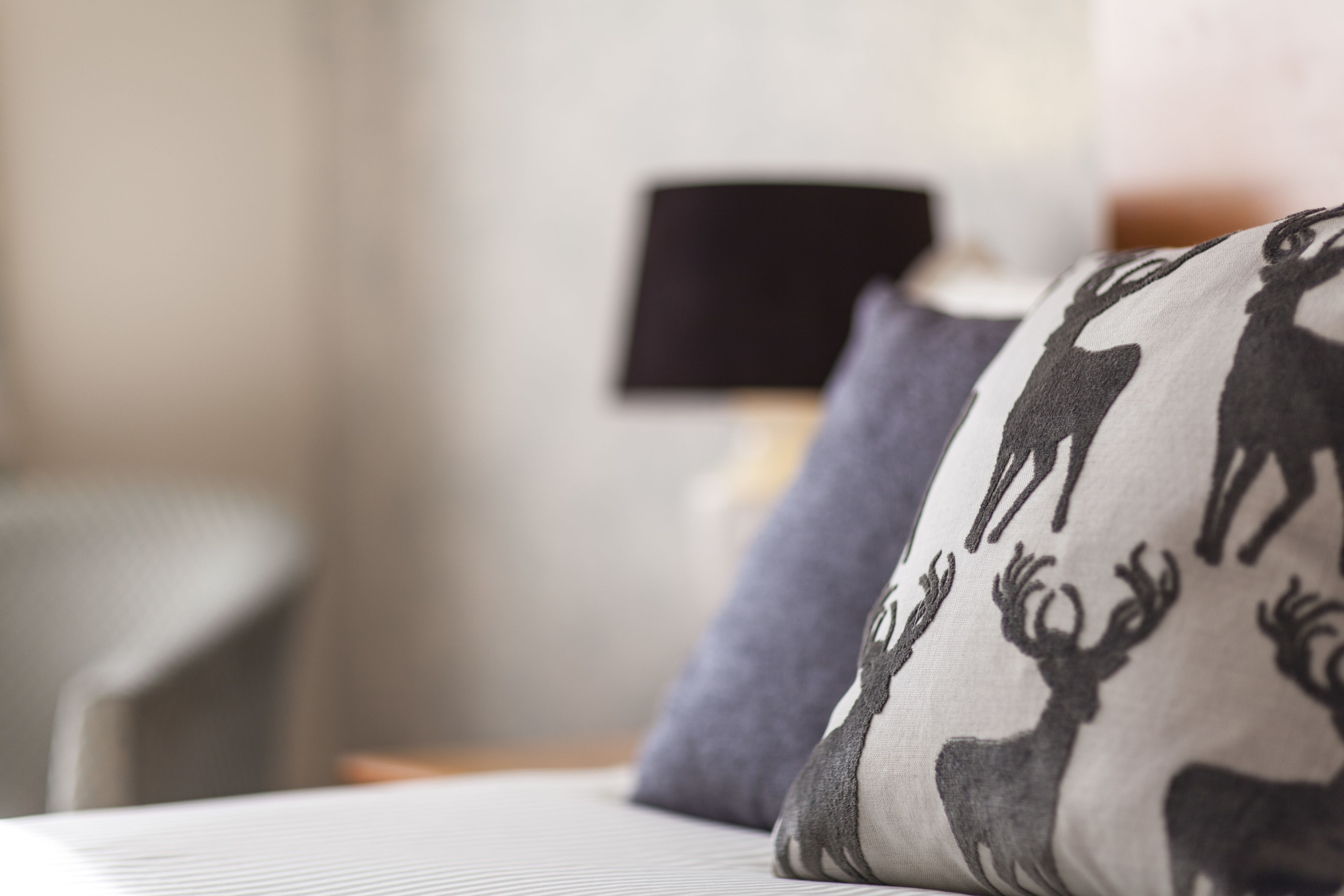 A bed with a pillow featuring a deer pattern.