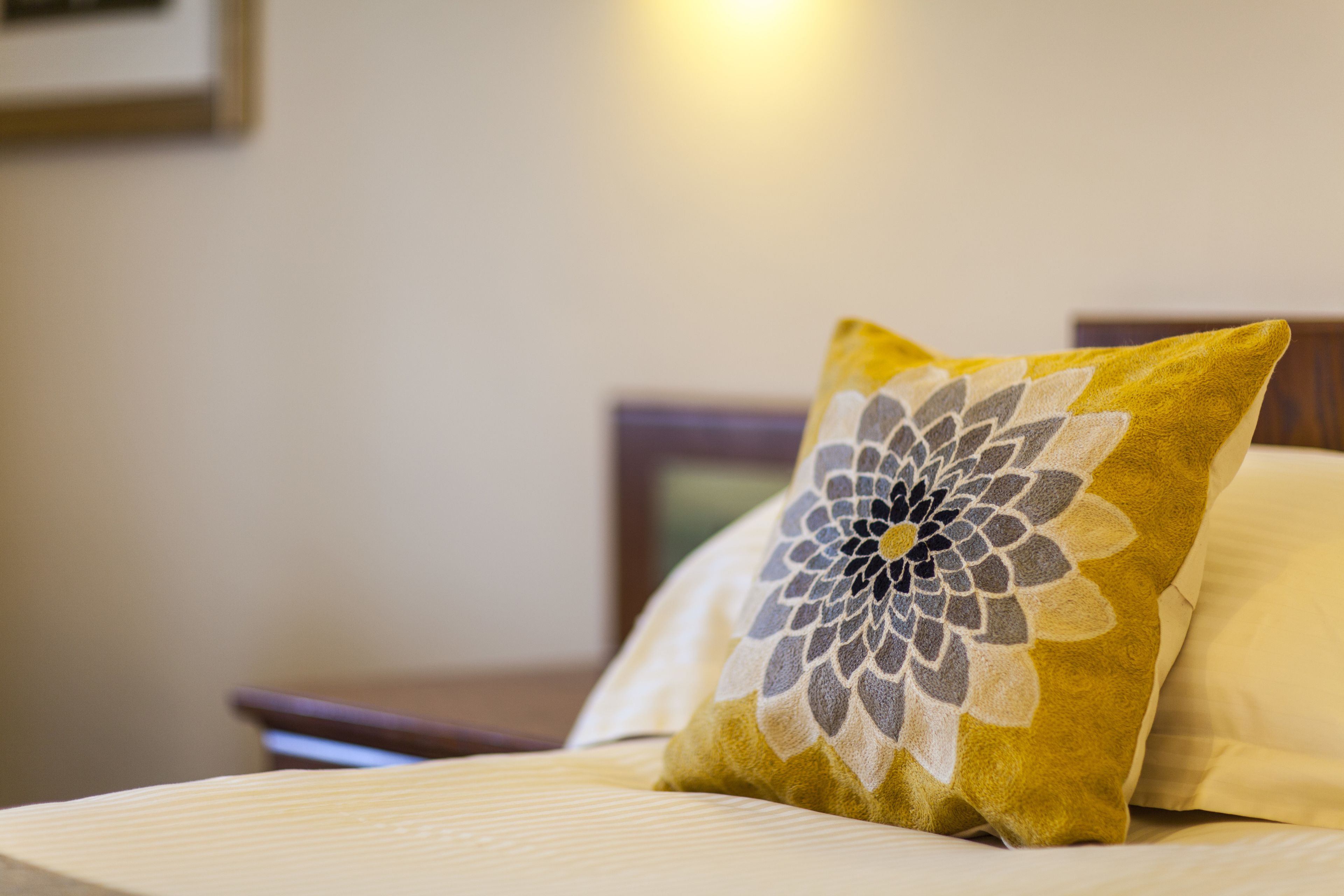 Un lit avec un oreiller à motifs floraux et un oreiller uni.
