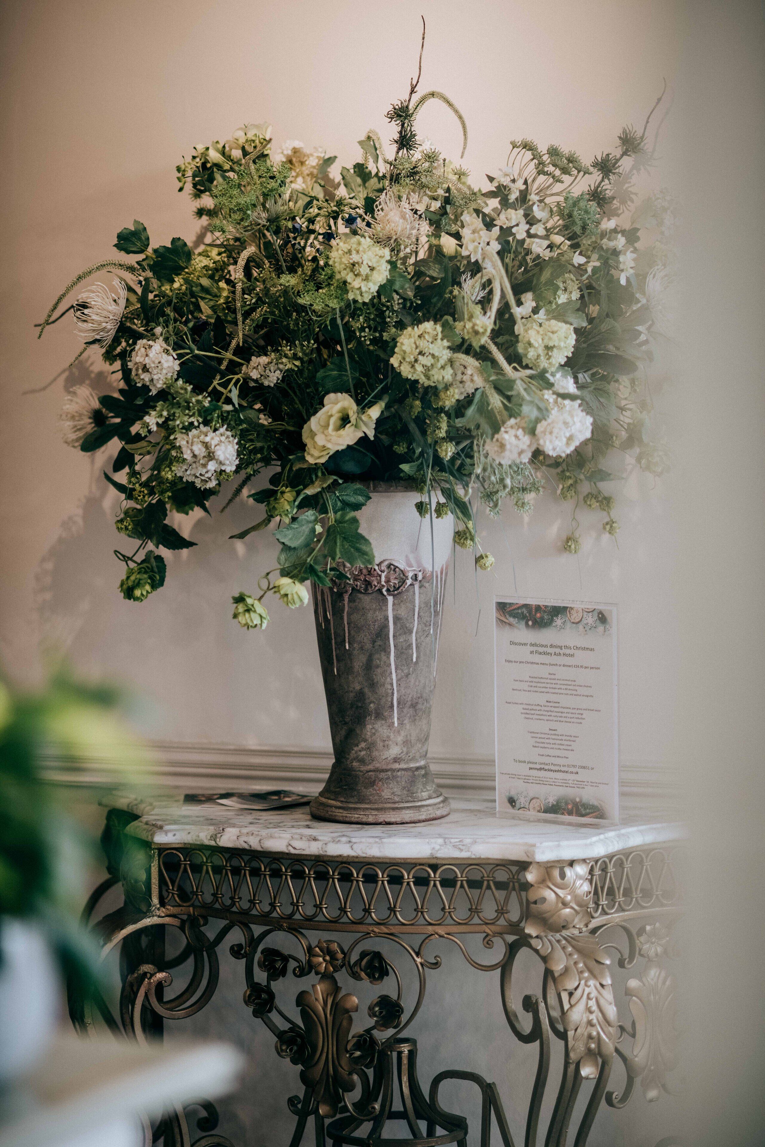 Eine große Vase mit verschiedenen Blumen auf einem Marmortisch.