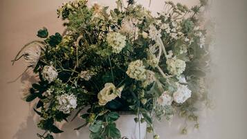 Eine große Vase mit verschiedenen Blumen auf einem Marmortisch.