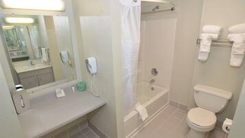 Un baño con lavamanos, espejo, inodoro y bañera.