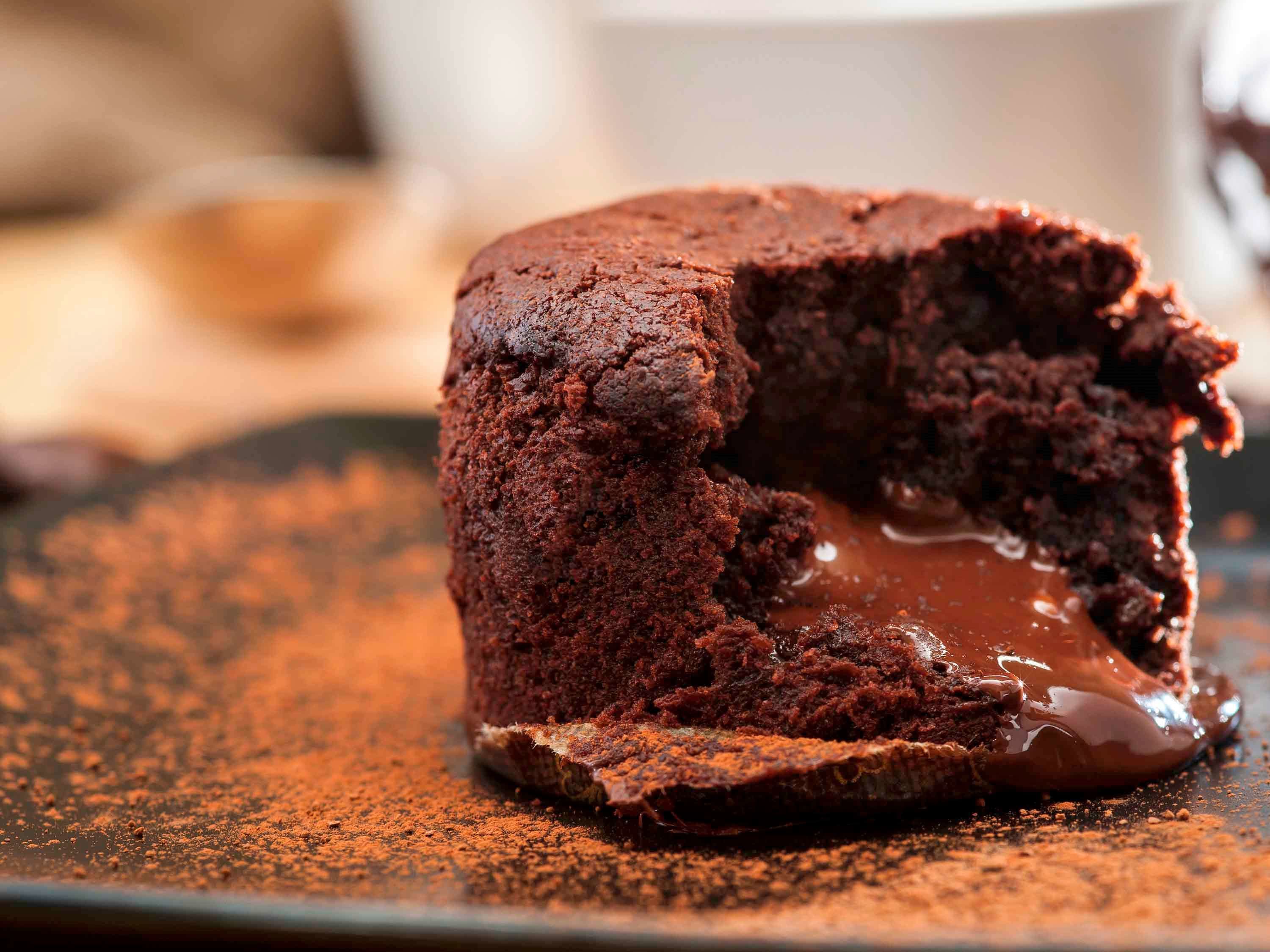 A chocolate lava cake with a gooey center, dusted with cocoa powder.