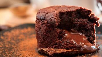 A chocolate lava cake with a gooey center, dusted with cocoa powder.