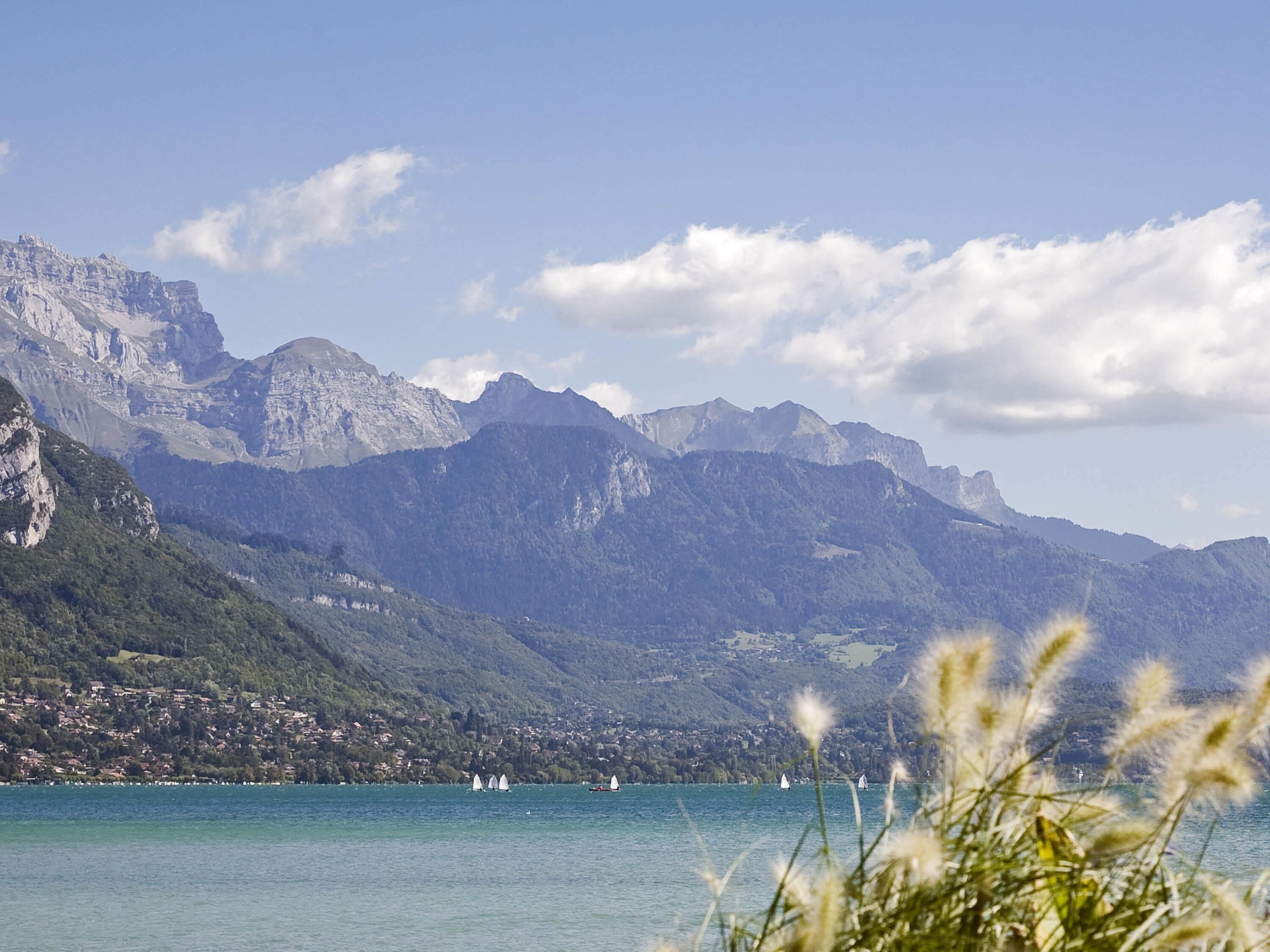 A mountainous landscape with a lake and sailboats.