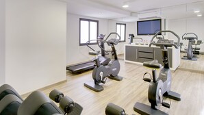 Un centre de remise en forme moderne équipé de machines de cardio, d’un téléviseur et d’un espace d’accueil.