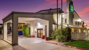 A modern hotel with a covered entrance, a sign indicating a 12th-floor parking, and a fire lane marking. - Quality Inn Tulsa Central (Tulsa)
