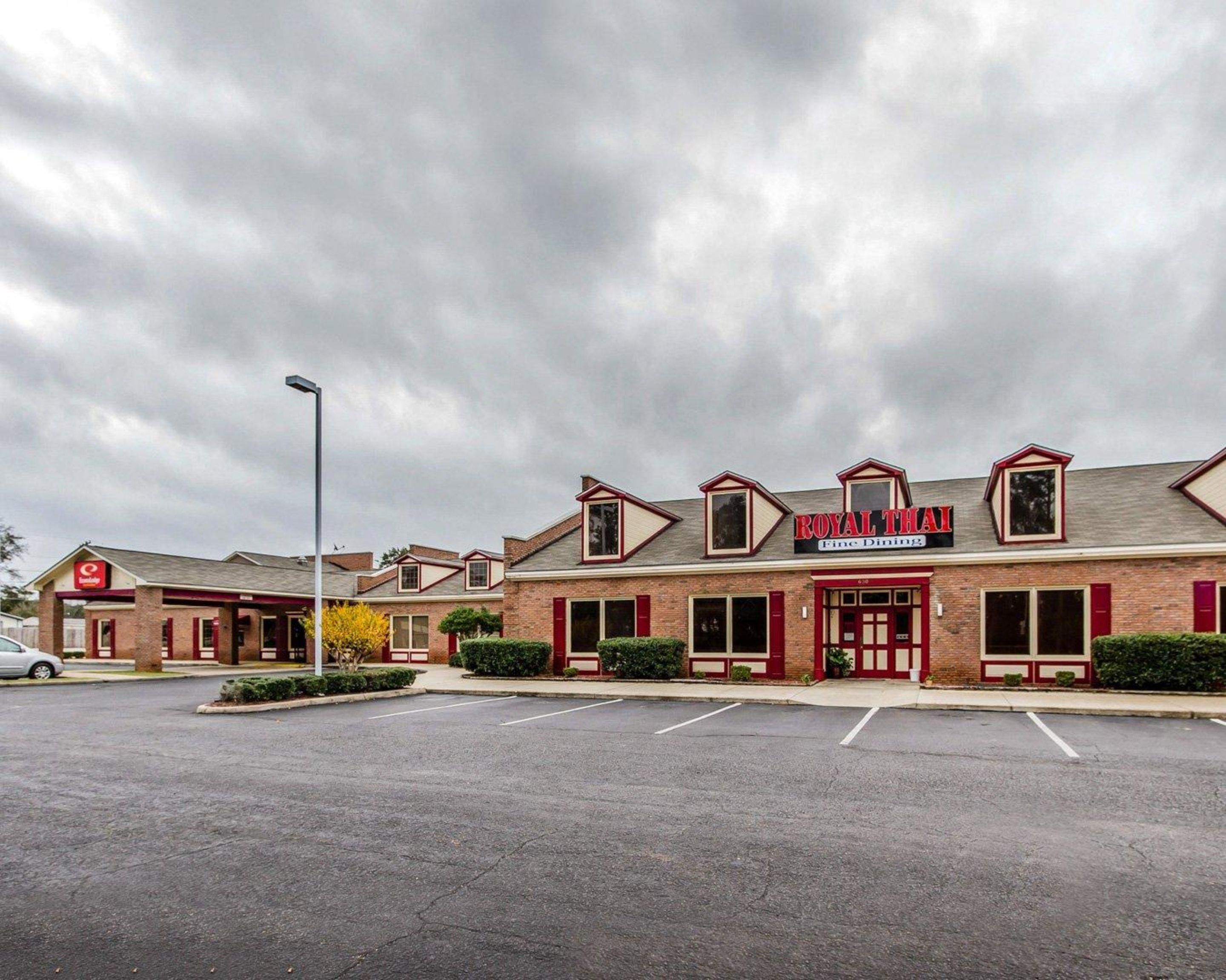 A Royal Thai Fine Dining restaurant with a brick facade, red shutters, and a parking lot in front.