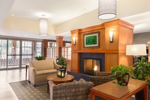 A spacious lobby with a fireplace, seating area, and large windows.