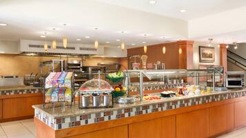 Una barra de desayuno con diversas opciones de comida y una estación de café.