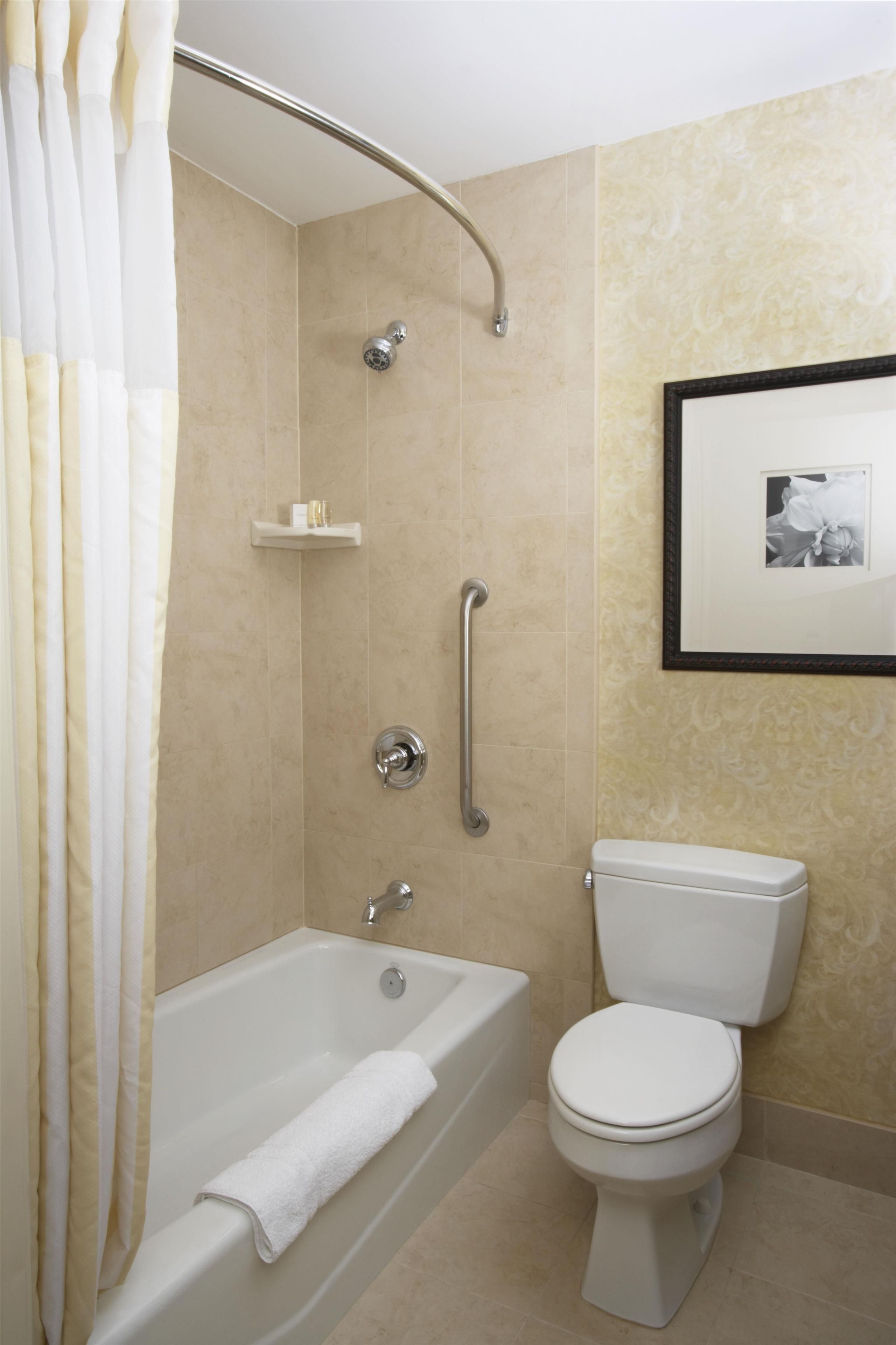 A bathroom with a bathtub, toilet, and a shower area.