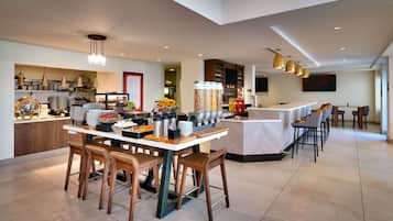 A modern kitchen and dining area with a buffet setup, bar stools, and a large island.
