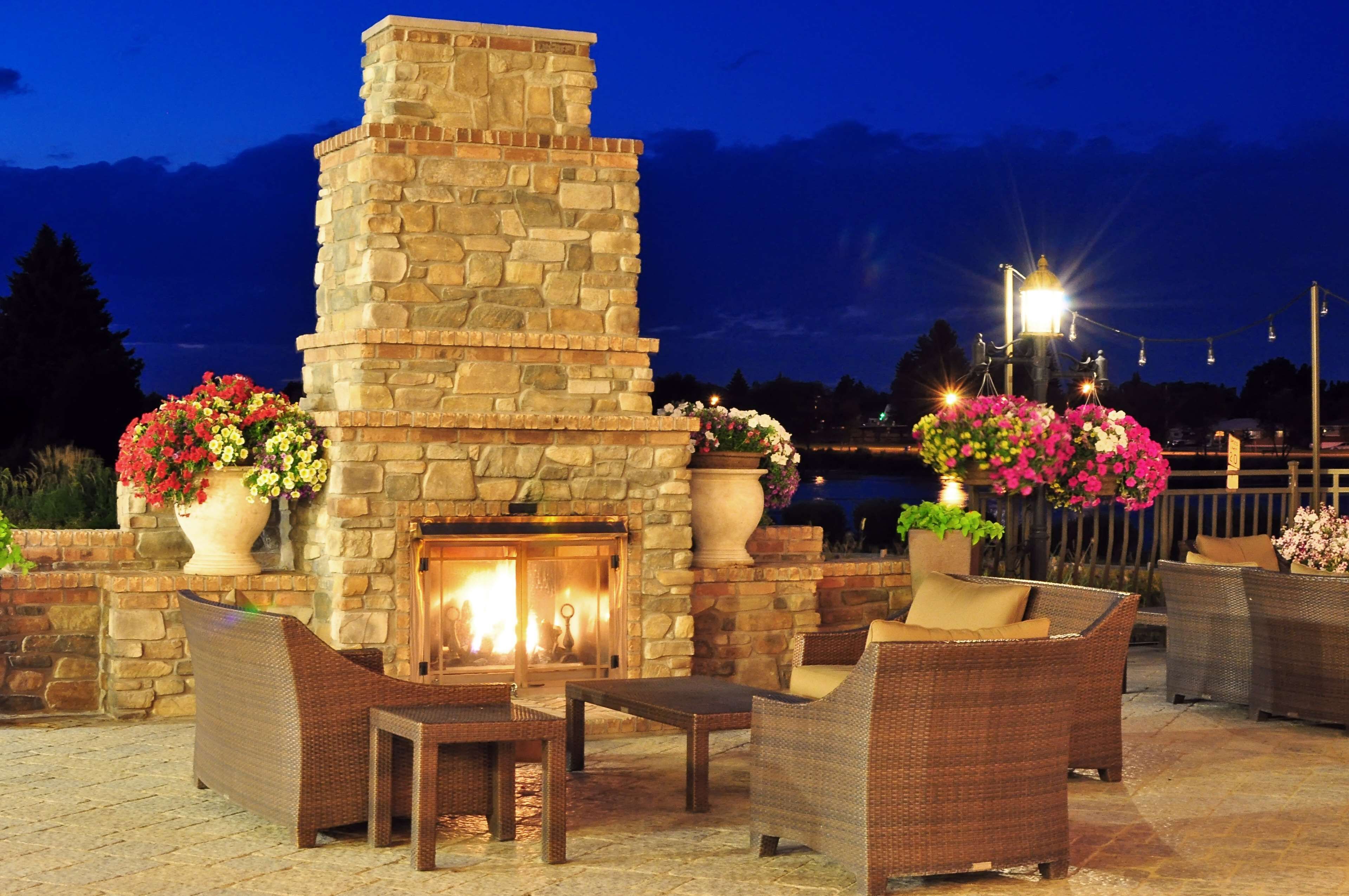 Una chimenea de piedra con asientos a su alrededor, con vista a un cuerpo de agua.