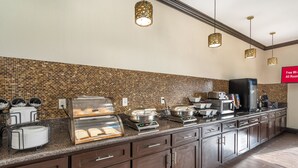 Eine Küche mit Ziegelrückwand, Edelstahlgeräten und einem Buffet-Aufbau.