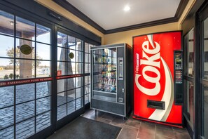 A Coca-Cola vending machine and an automatic caution door in a commercial setting. - Red Roof Inn & Suites Sulphur Springs (Sulphur Springs)