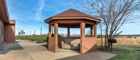 Un kiosque doté d’un toit en tuiles, d’un chemin en béton et d’une boîte aux lettres.