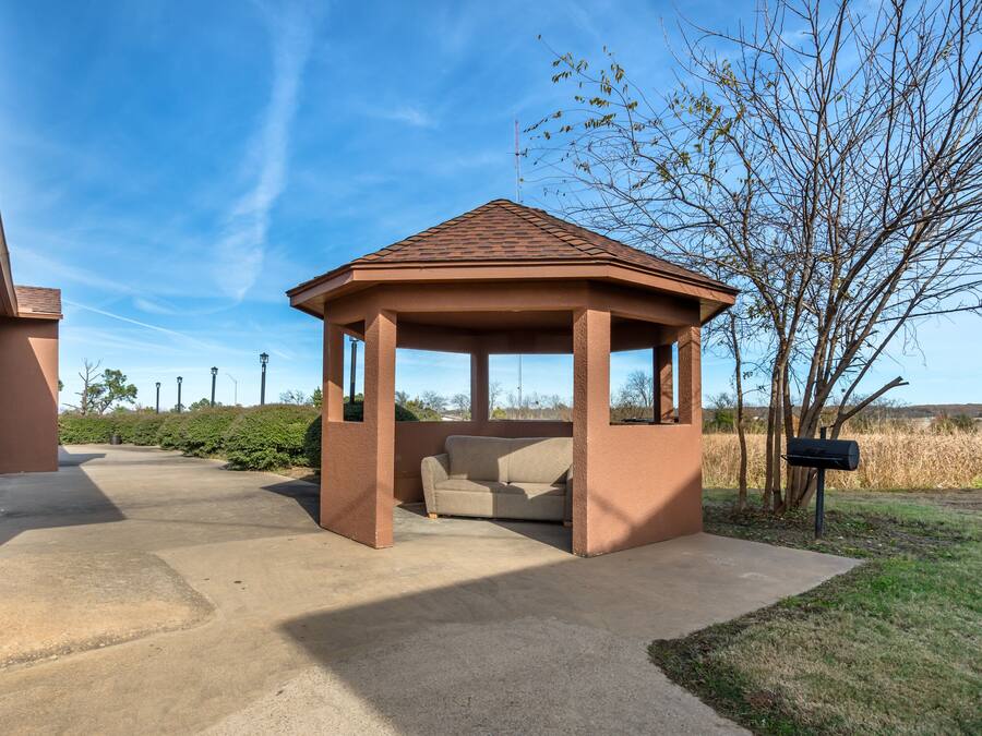 Un kiosque doté d’un toit en tuiles, d’un chemin en béton et d’une boîte aux lettres.