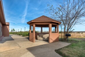 A gazebo with a tiled roof, a concrete pathway, and a mailbox. - Red Roof Inn & Suites Sulphur Springs (Sulphur Springs)