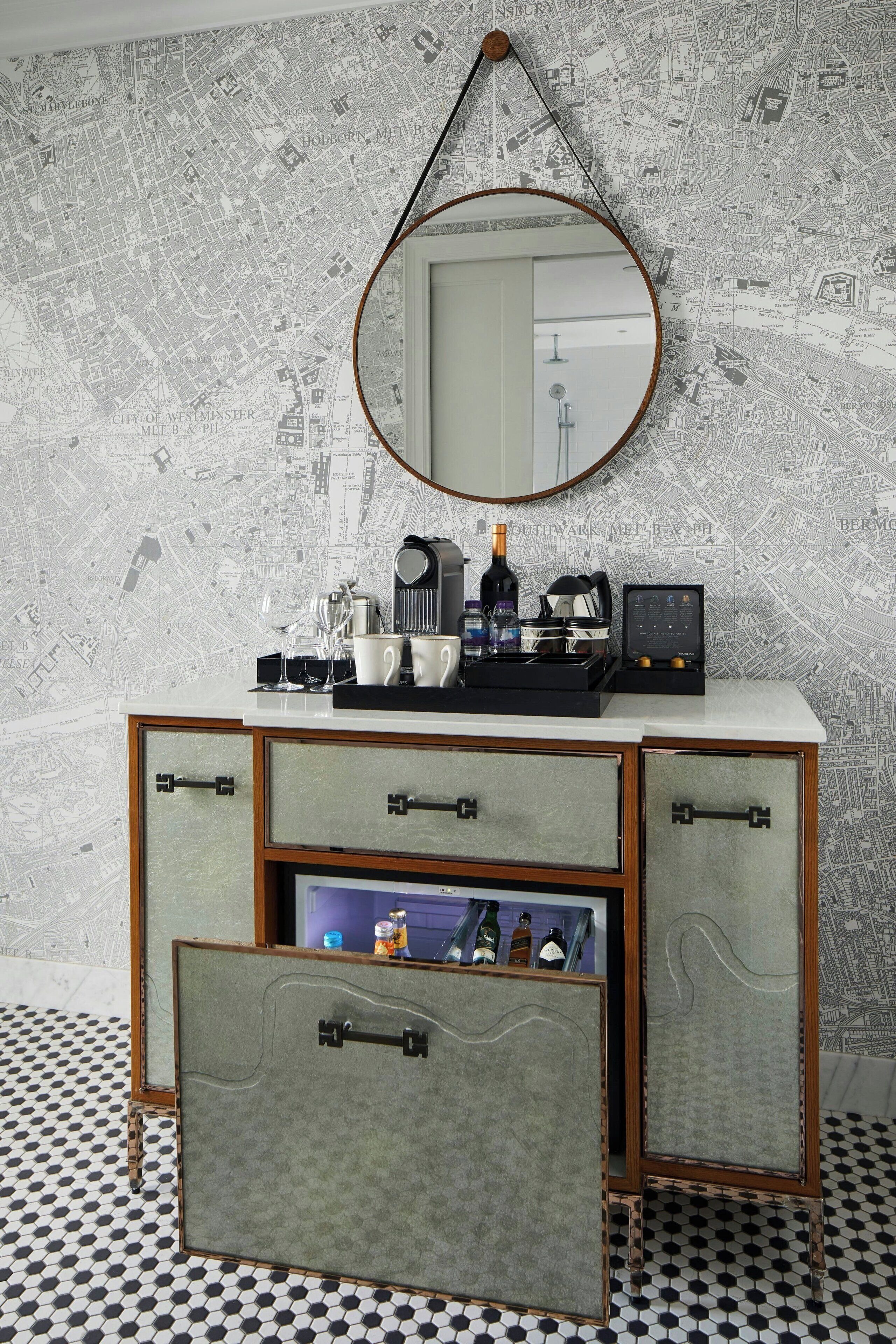 A vintage-style dresser with a mirror, drawers, and a tray holding bottles and glasses.