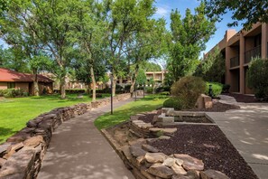 A landscaped pathway with stone borders, a grassy area, and trees. - Holiday Inn Canyon De Chelly by IHG (Chinle)