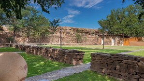 A stone pathway leading to a rustic building with a wooden fence and a clear blue sky. - Holiday Inn Canyon De Chelly by IHG (Chinle)